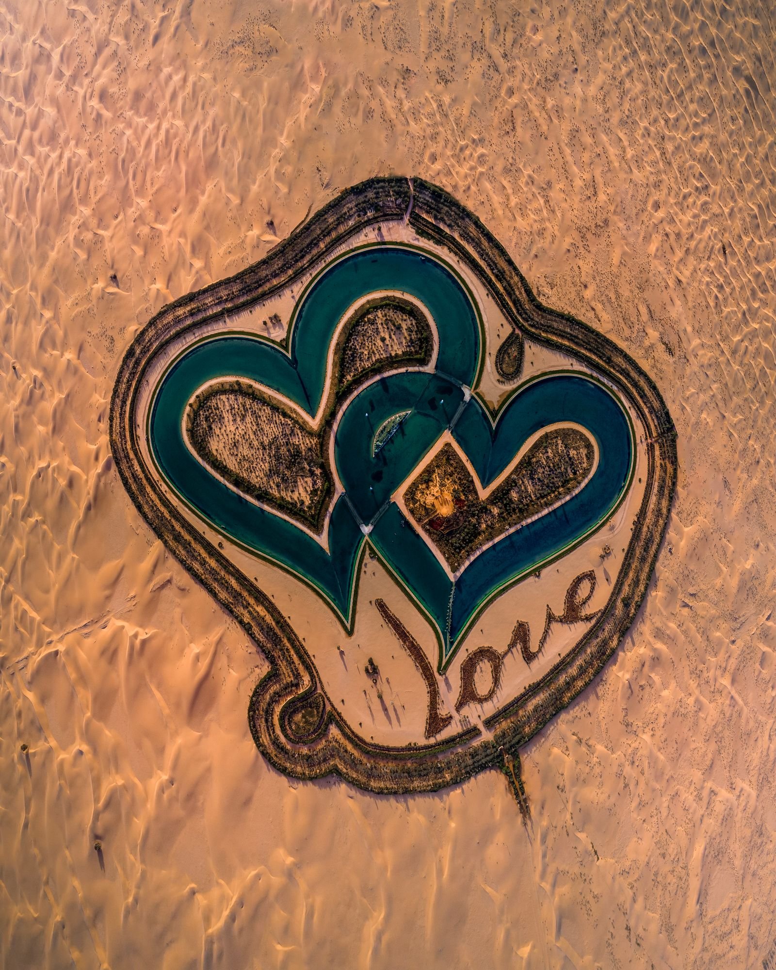 Love Lake Dubai from above with trees spelling LOVE beside the heart-shaped lakes