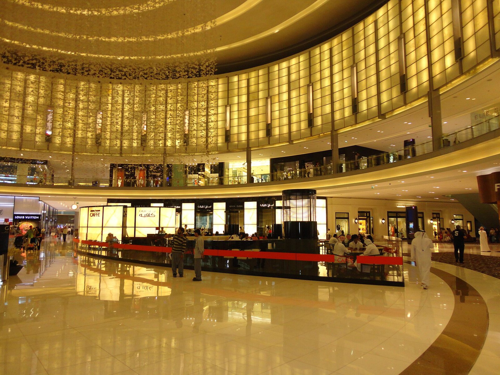 The golden Fashion Avenue atrium inside The Dubai Mall, with glowing wall panels and luxury shop fronts