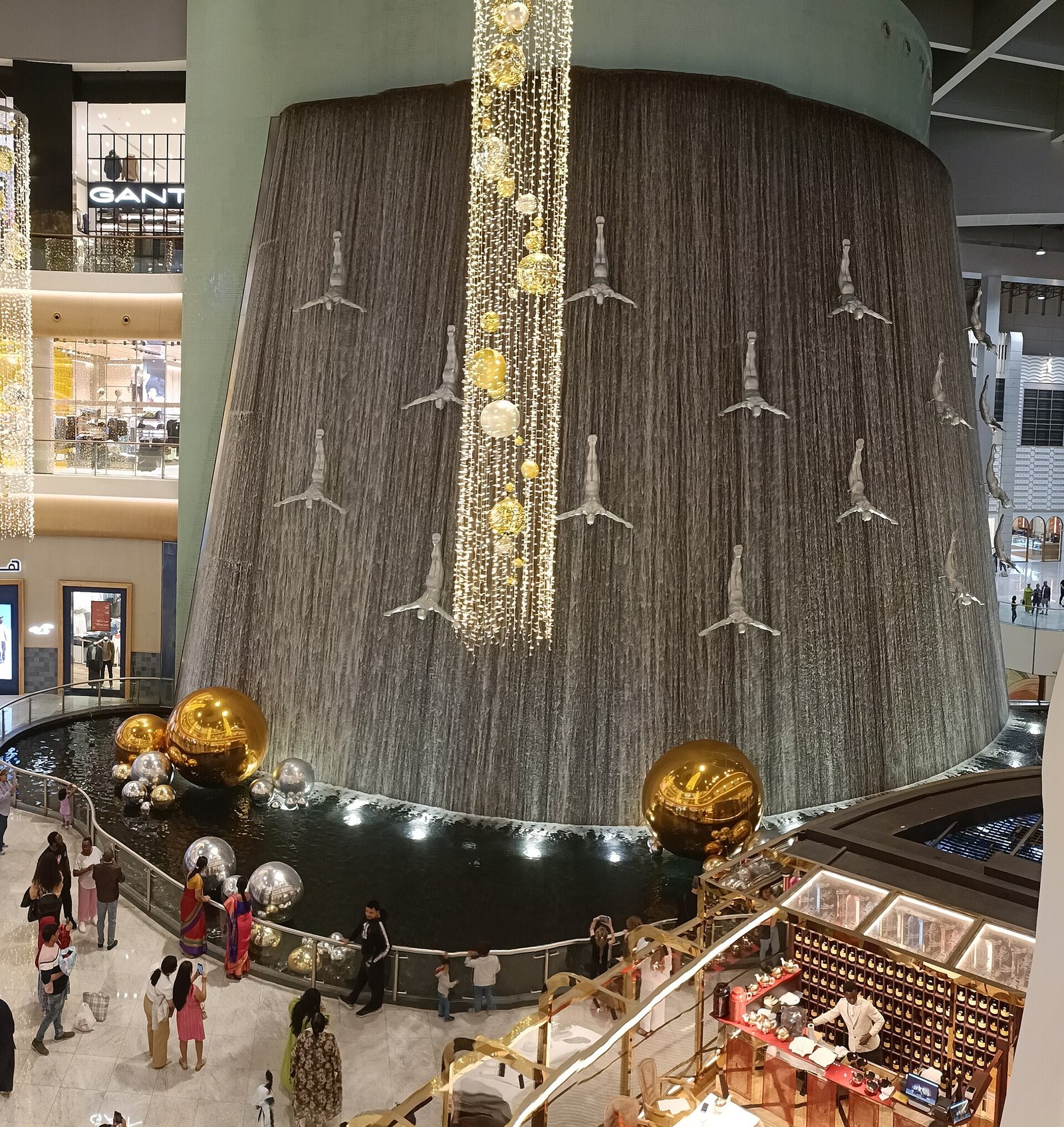 The Human Waterfall inside The Dubai Mall, a curved wall of water covered with silver diver statues