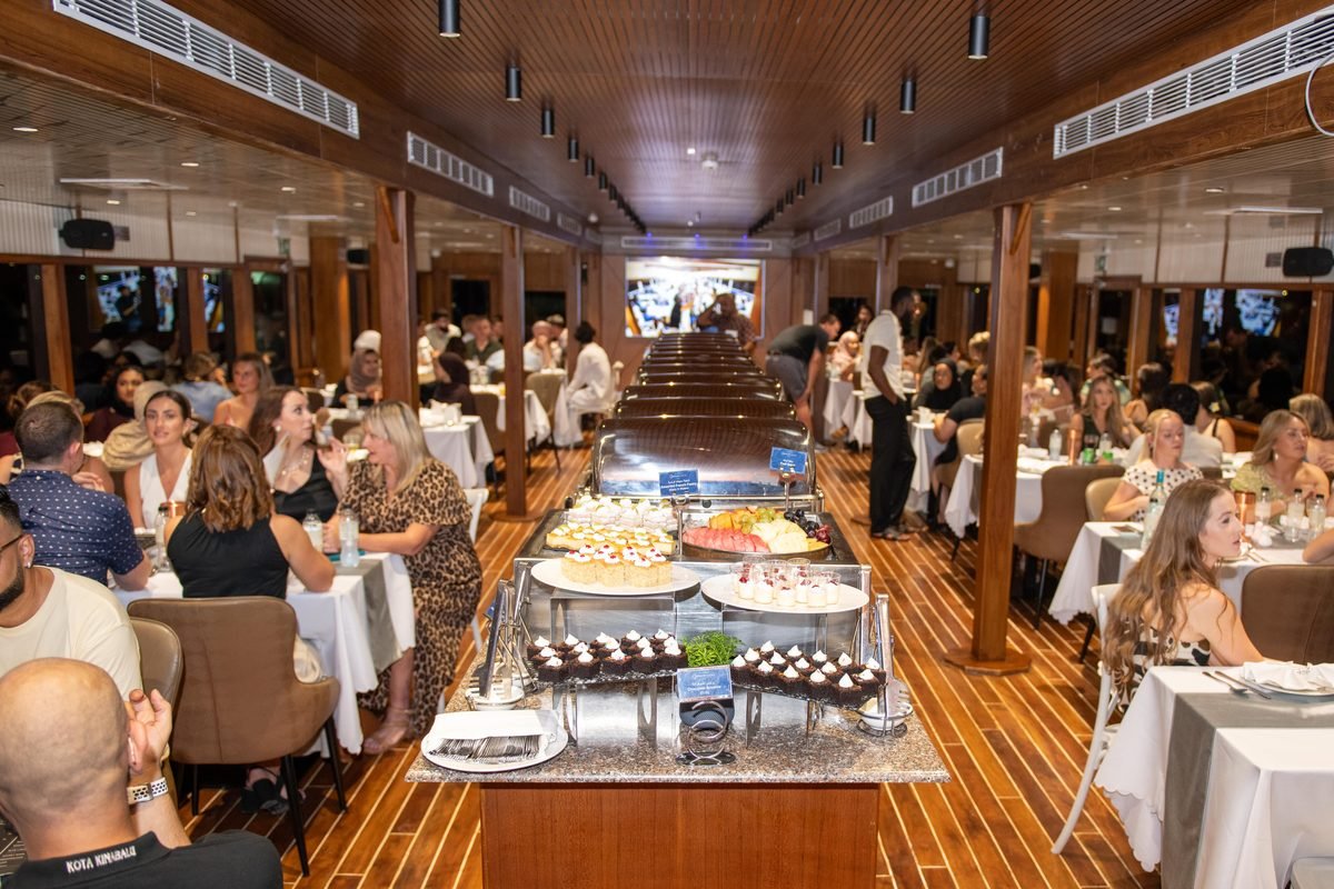 The buffet dinner on a dhow cruise in Dubai, with guests seated in the wooden dining deck