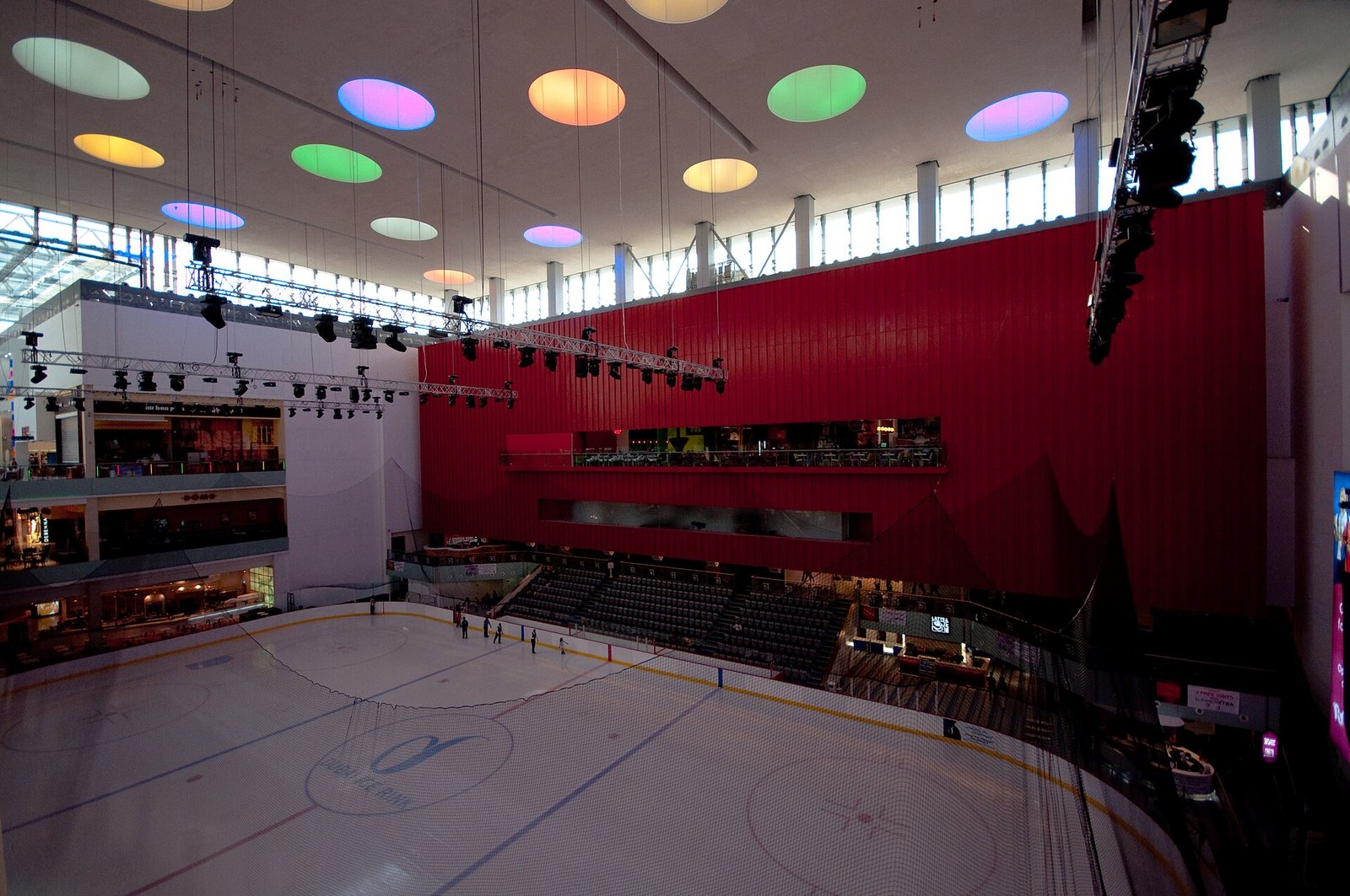 The Olympic-size Dubai Ice Rink inside The Dubai Mall, under a giant red wall and coloured ceiling lights