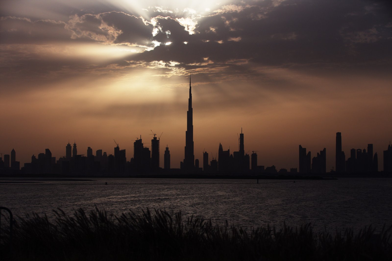 The Downtown Dubai skyline with the Burj Khalifa at sunset, seen across the water