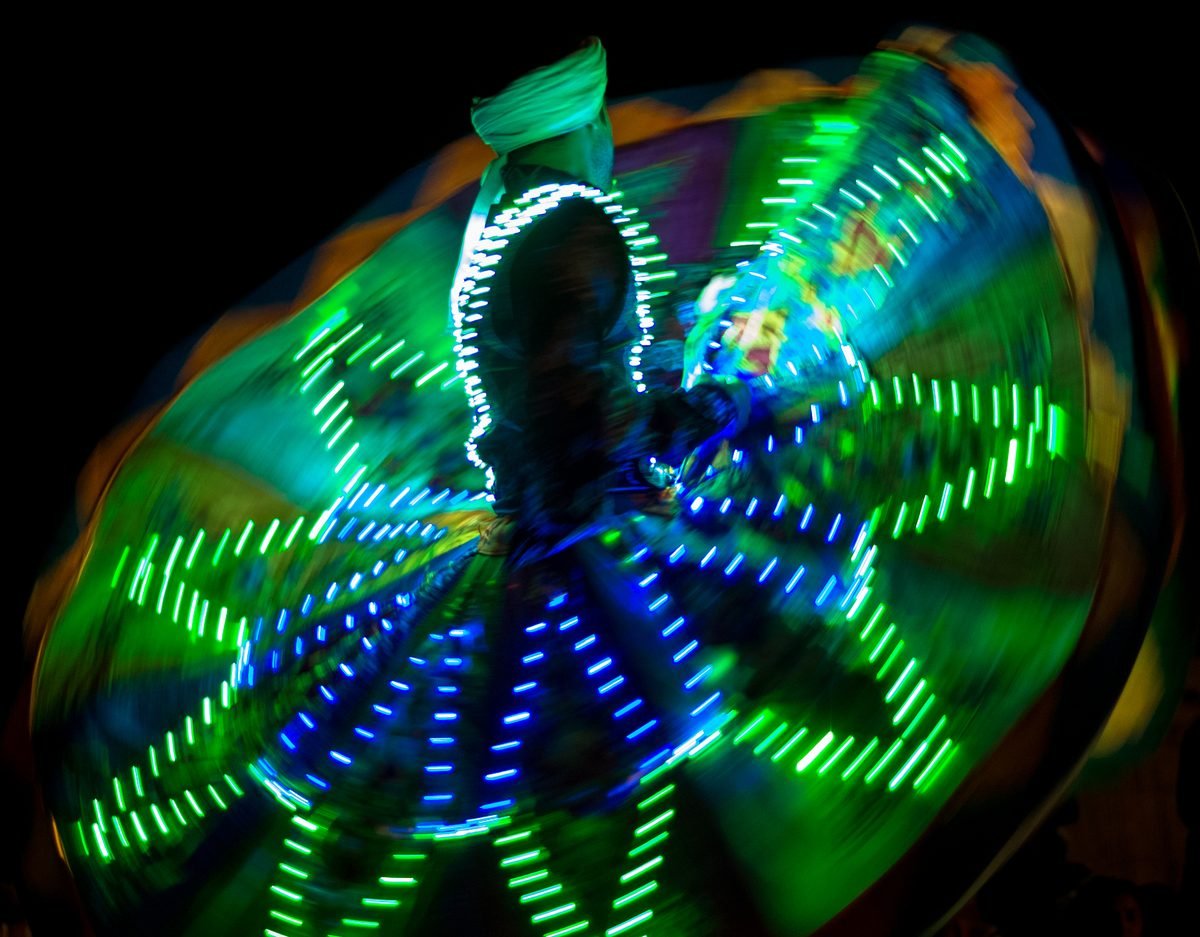 A Tanoura dancer spinning in a skirt of coloured lights, the live show families watch on a dhow cruise in Dubai