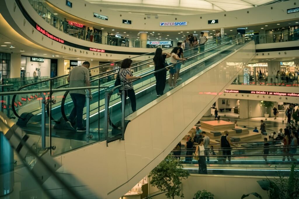 Shoppers on escalators inside a large outlet shopping mall in Dubai
